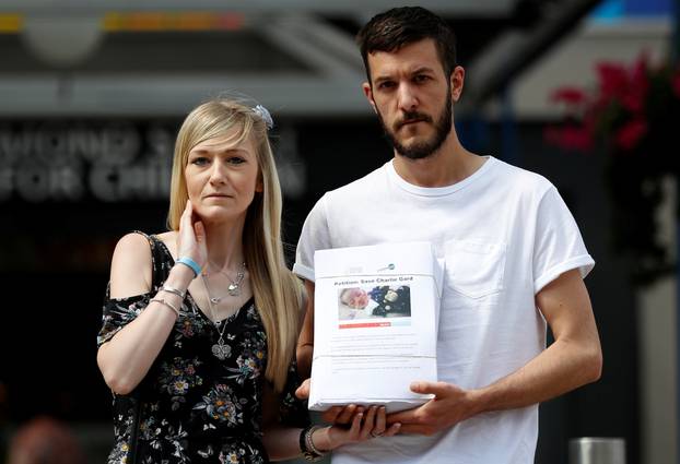 The parents of critically ill baby Charlie Gard, Connie Yates and Chris Gard, pose for the media with a petition, outside Great Ormond Street Hospital, in central London