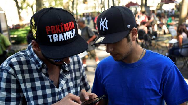 A man wears a Pokemon-themed hat as he plays the augmented reality mobile game "Pokemon Go" by Nintendo in Bryant Park, New York City