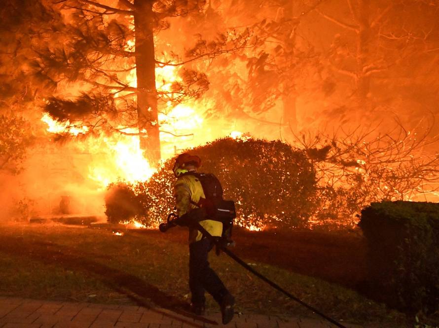 Firefighters battle a wind-driven wildfire called the Saddle Ridge fire in the early morning hours Friday in Porter Ranch