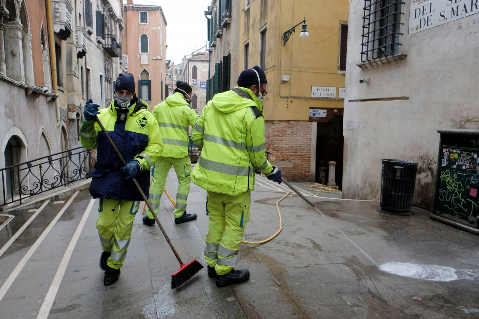 Workers sanitise a bridge as a measure against the coronavirus disease (COVID-19) in Venice