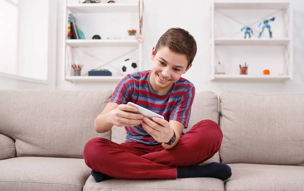 Teenager playing games on smartphone