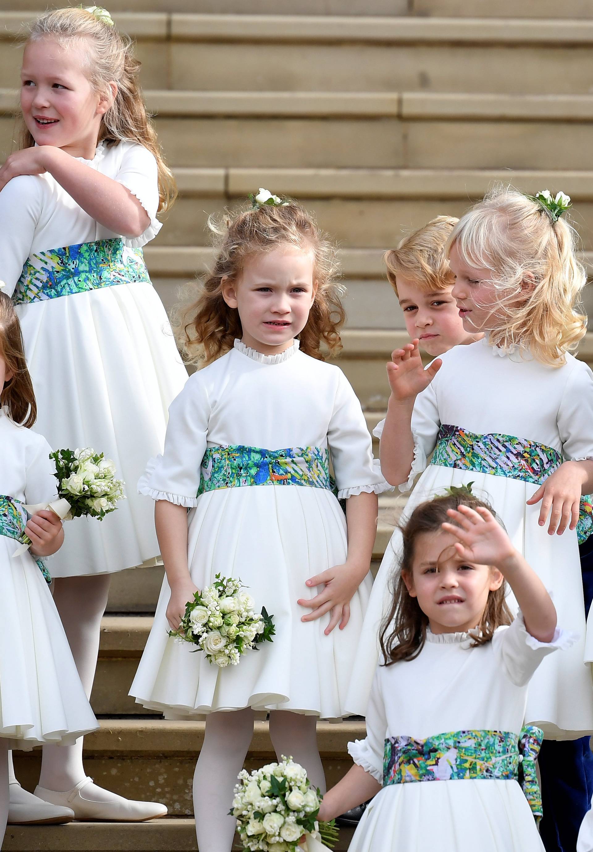 The bridesmaids and page boys, including Prince George and Princess Charlotte, wave as they leave after the royal wedding of Britain's Princess Eugenie of York and her husband Jack Brooksbank at St George's Chapel in Windsor Castle