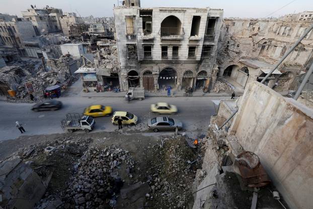 People and cars are seen in old town in Aleppo