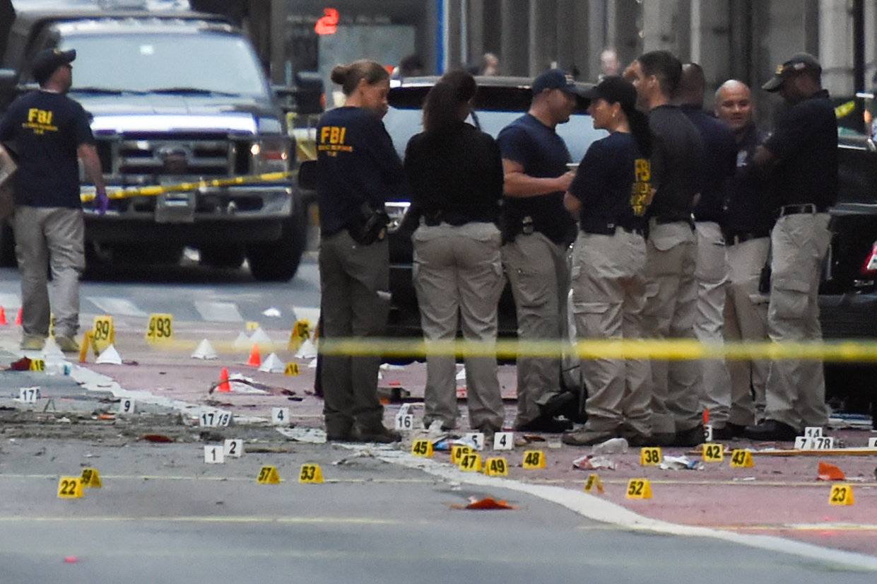 FBI officials stand amid past evidence markers near site of explosion in New York