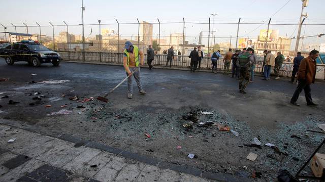 Iraqi security forces inspect the site of a bomb attack in Baghdad