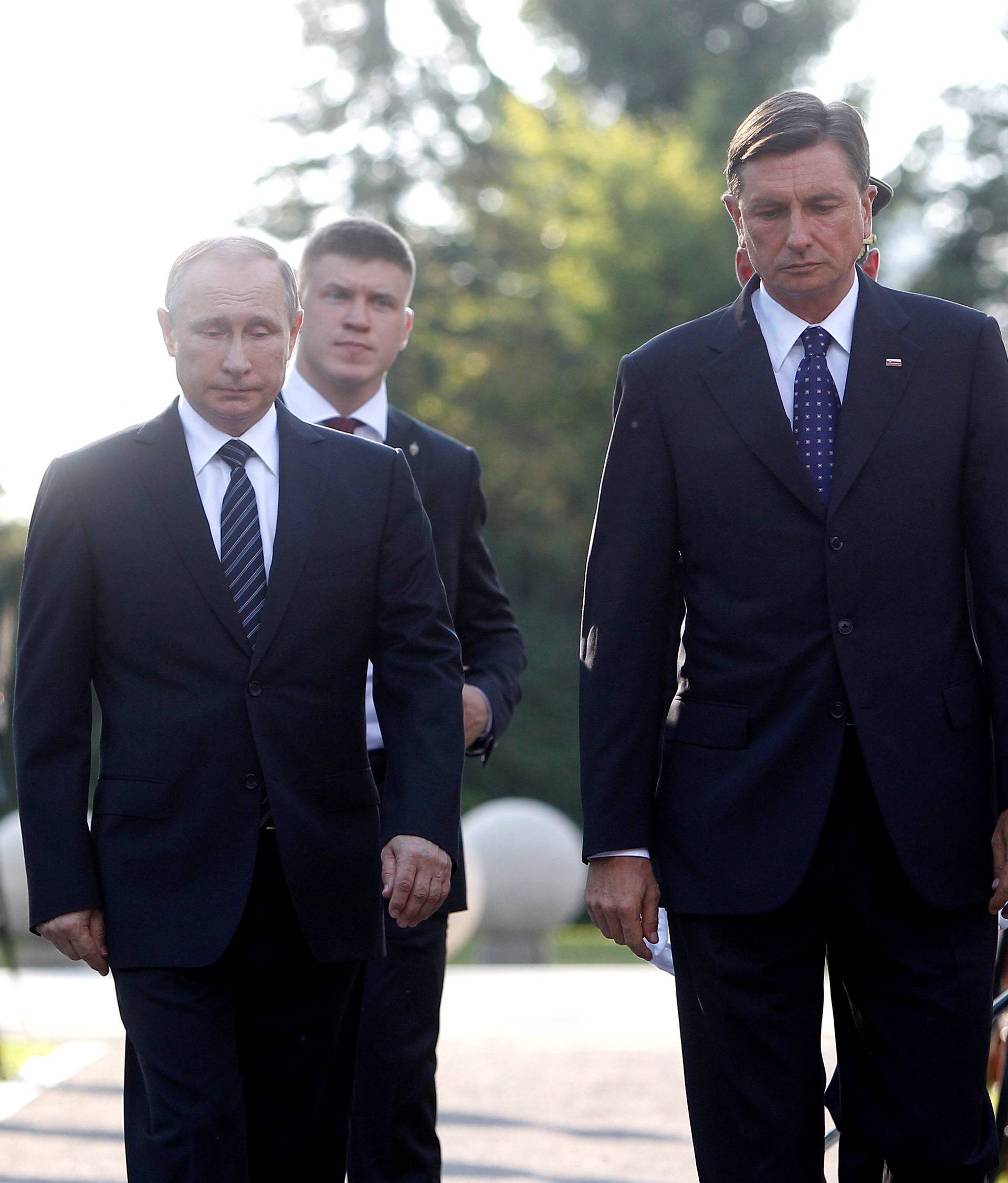 Russian President Vladimir Putin and Slovenian President Borut Pahor (R) unveil the memorial for all fallen Russian soldiers in Slovenia during World War One and Two, in Ljubljana