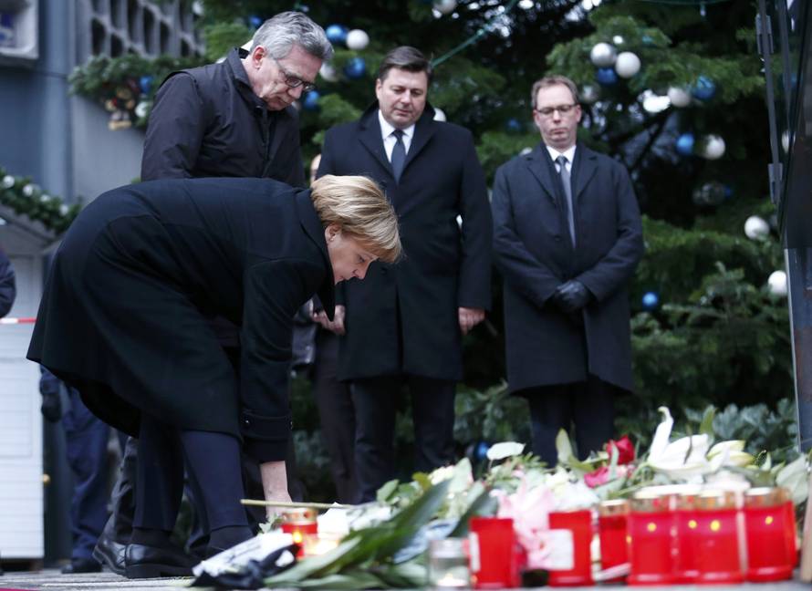 German Chancellor Angela Merkel lays flowers at the Christmas market in Berlin