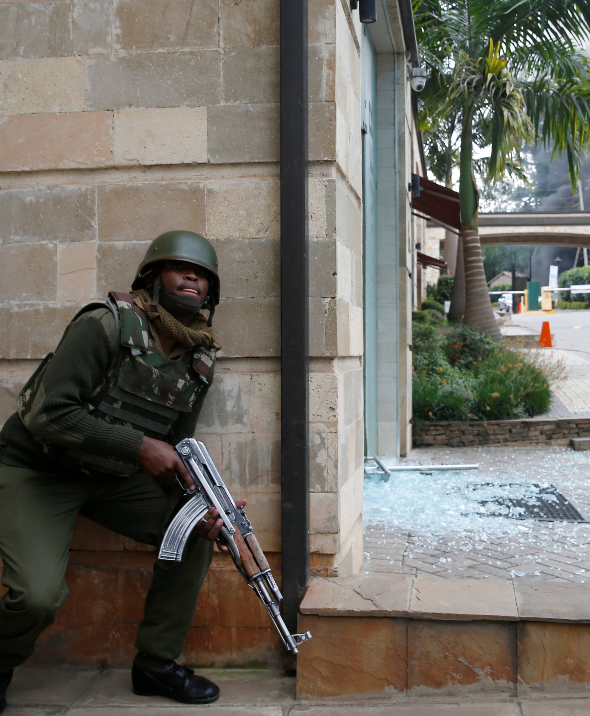 A policeman takes position at the scene where explosions and gunshots were heard at the Dusit hotel compound, in Nairobi
