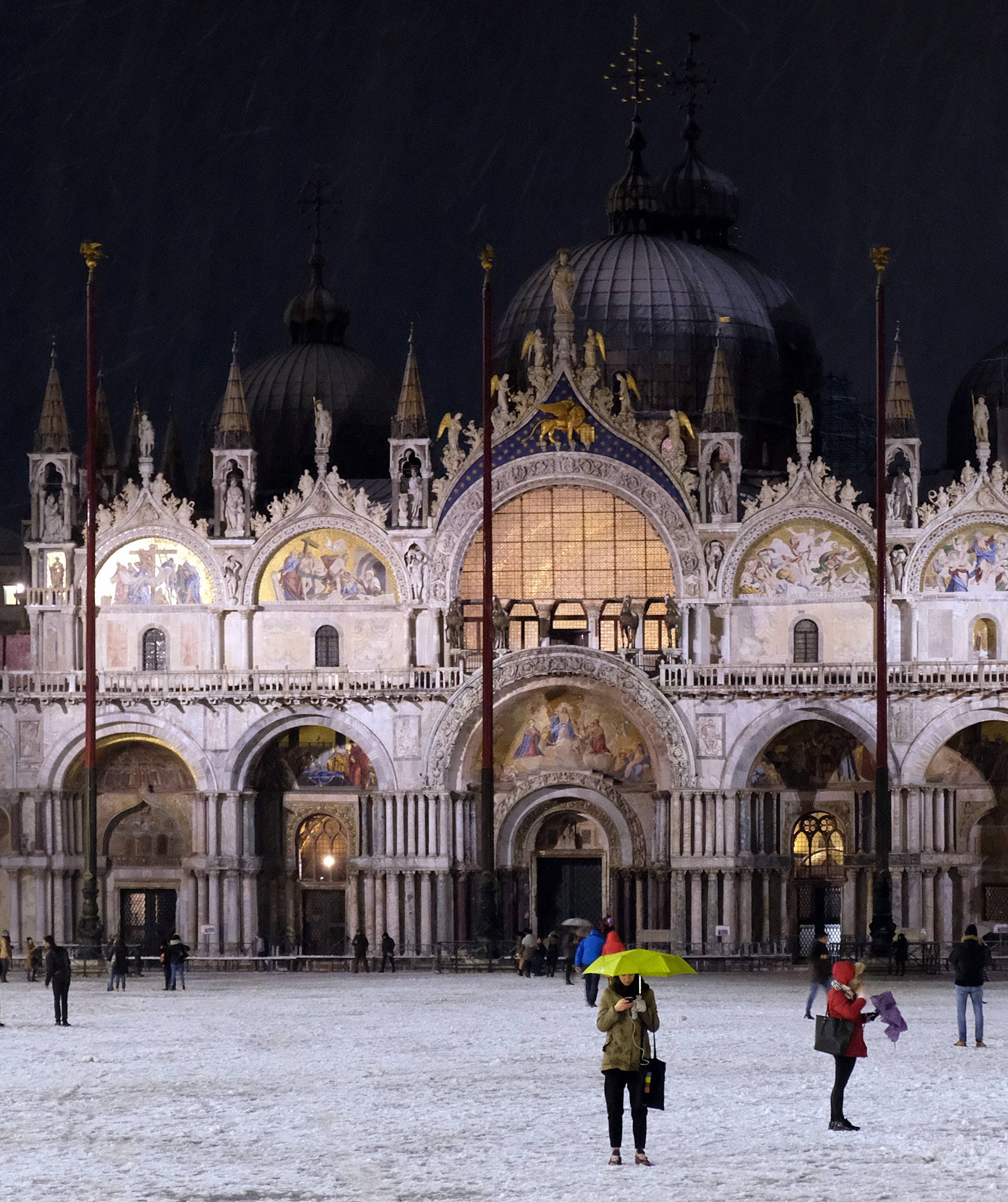 People are seen in St.Mark square during snowfall in the Venice lagoon