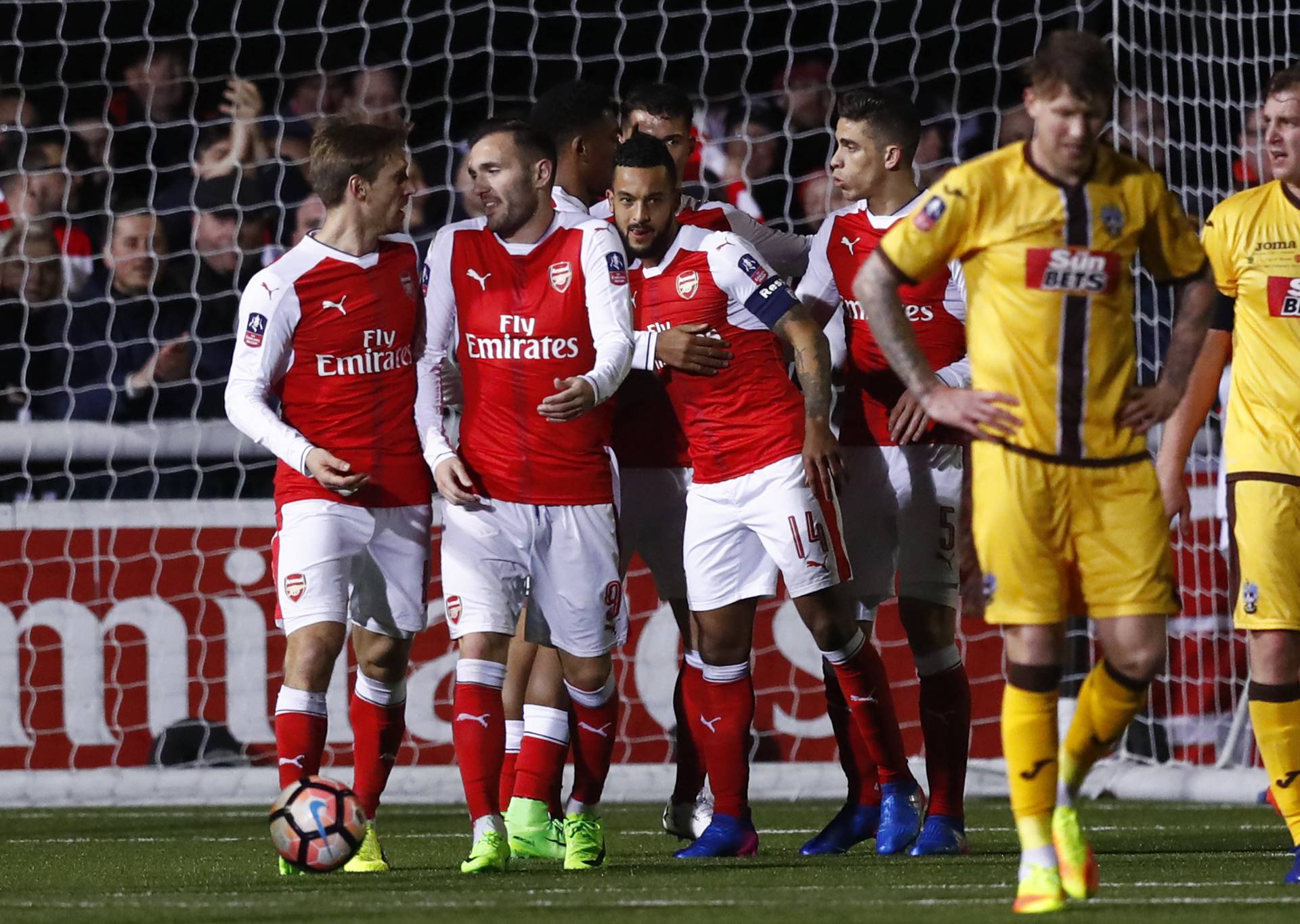 Arsenal's Theo Walcott celebrates scoring their second goal with Nacho Monreal, Lucas Perez and Gabriel Paulista as Sutton United's Jamie Collins looks dejected