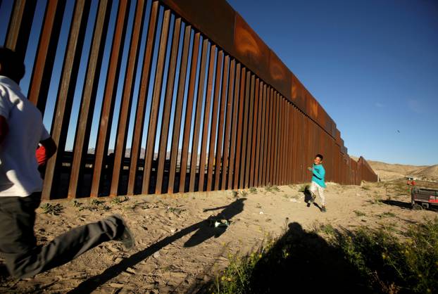 FILE PHOTO: Children run along the border fence between Mexico and the United States during an inter-religious service against U.S. President Donald Trump