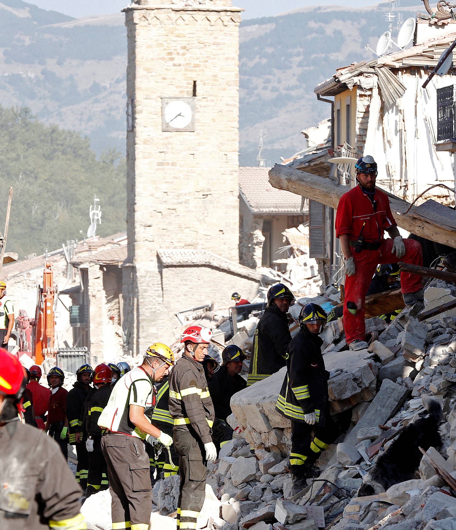 Firefighters and rescuers work following an earthquake in Amatrice