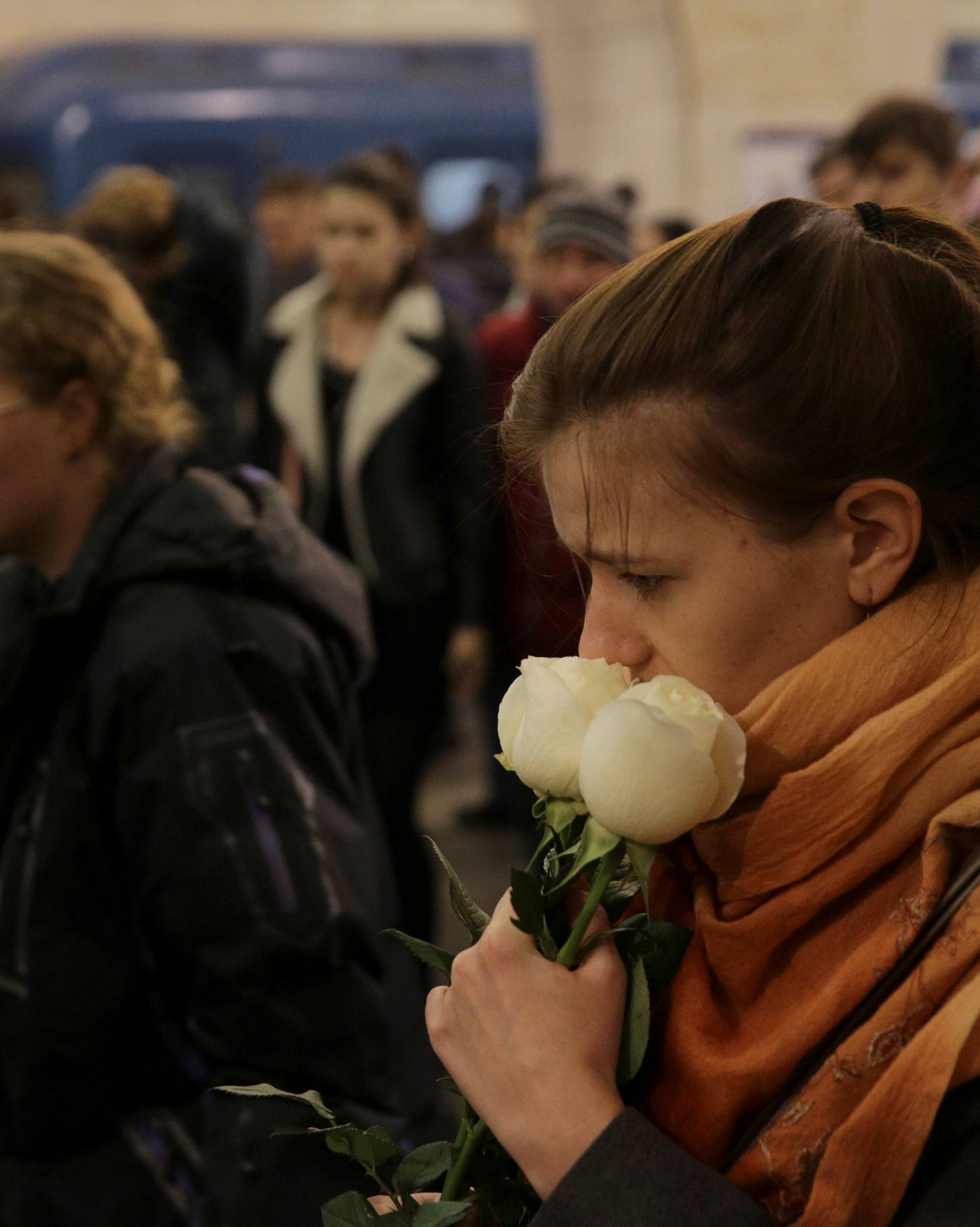 People hold flowers as they mourn for victims of blast in St. Petersburg metro at Tekhnologicheskiy institut metro station in St. Petersburg