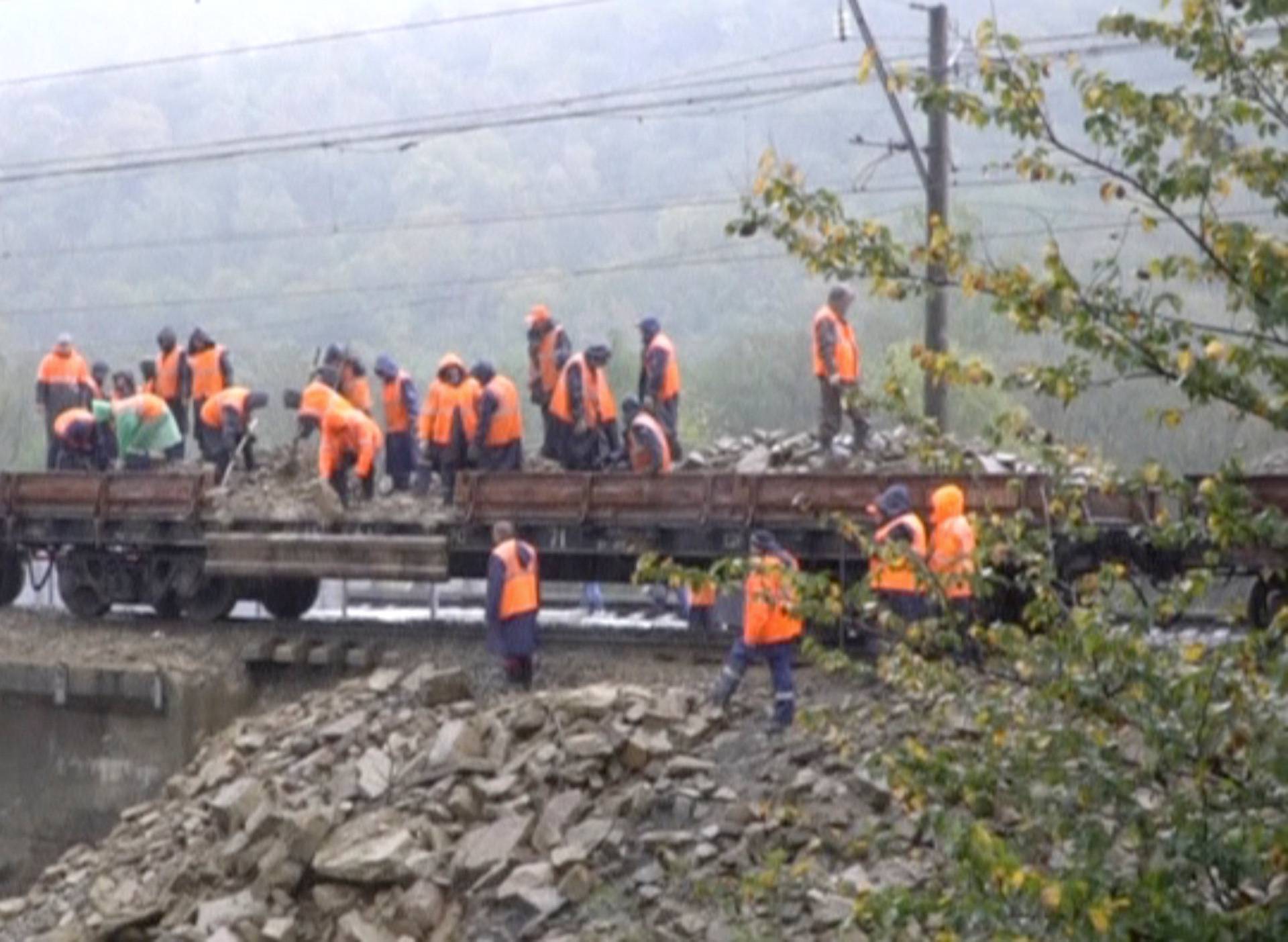A still image taken from a video footage shows emergency service workers unloading stones on a railway bridge following a recent flood in Krasnodar Region