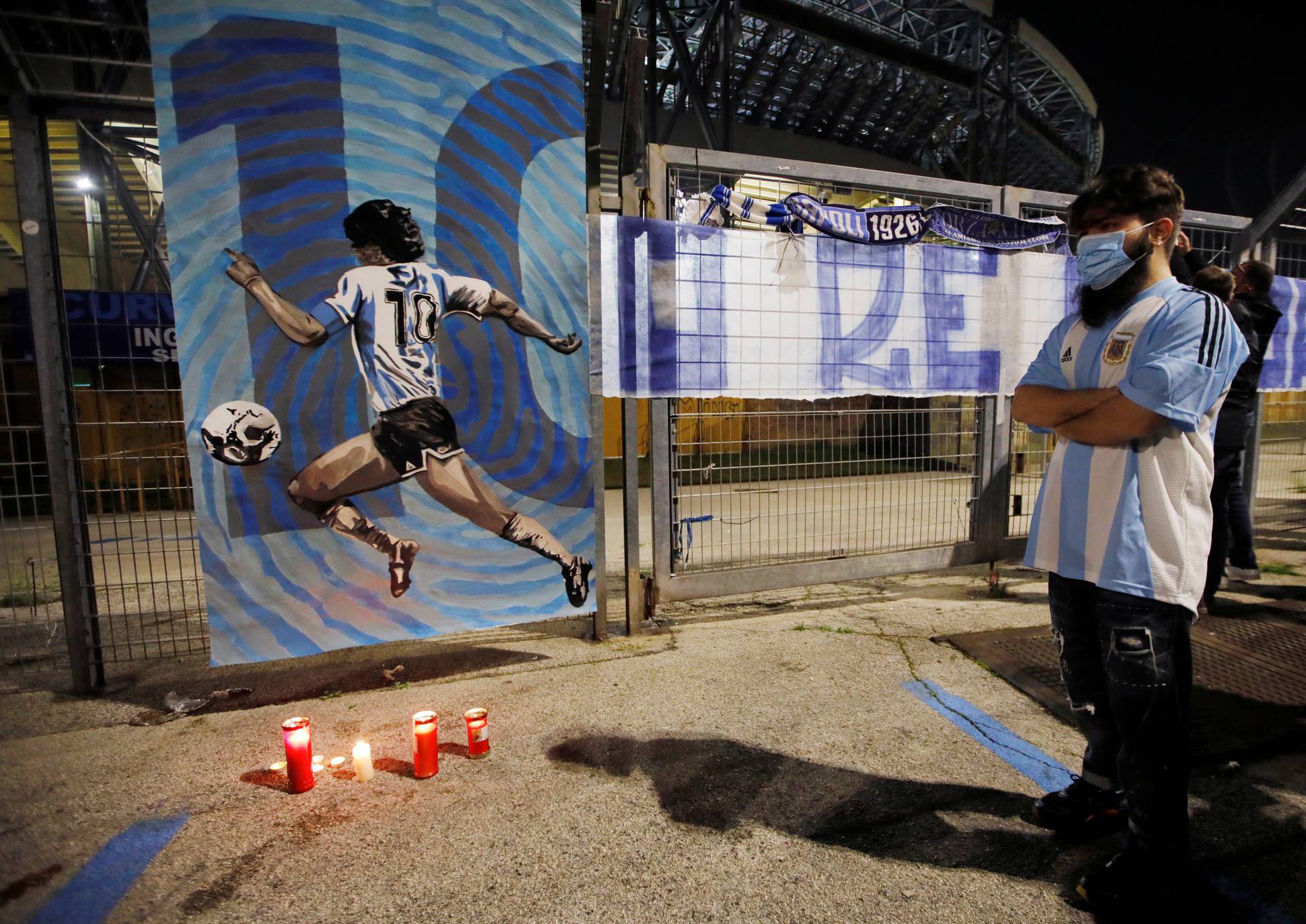 People gather to mourn the death of Argentine soccer legend Diego Maradona outside San Paolo stadium in Naples