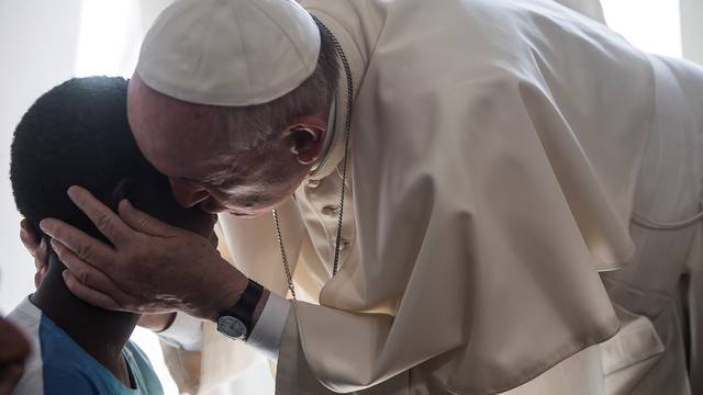 Pope Francis kisses a member of the Pope John XXIII community in Rome