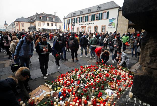 People pay their respects near the site where a car crashed into pedestrians in Trier