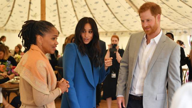 Meghan, Duchess of Sussex, her mother, Doria Ragland and Britain's Prince Harry take part in the launch of a cookbook with recipes from a group of women affected by the Grenfell Tower fire at Kensington Palace in London