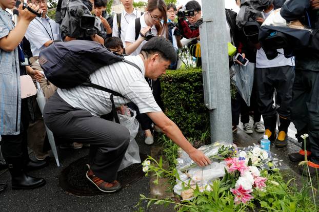 A man placed flowers near the torched Kyoto Animation building to mourn the victims of the arson attack in Kyoto