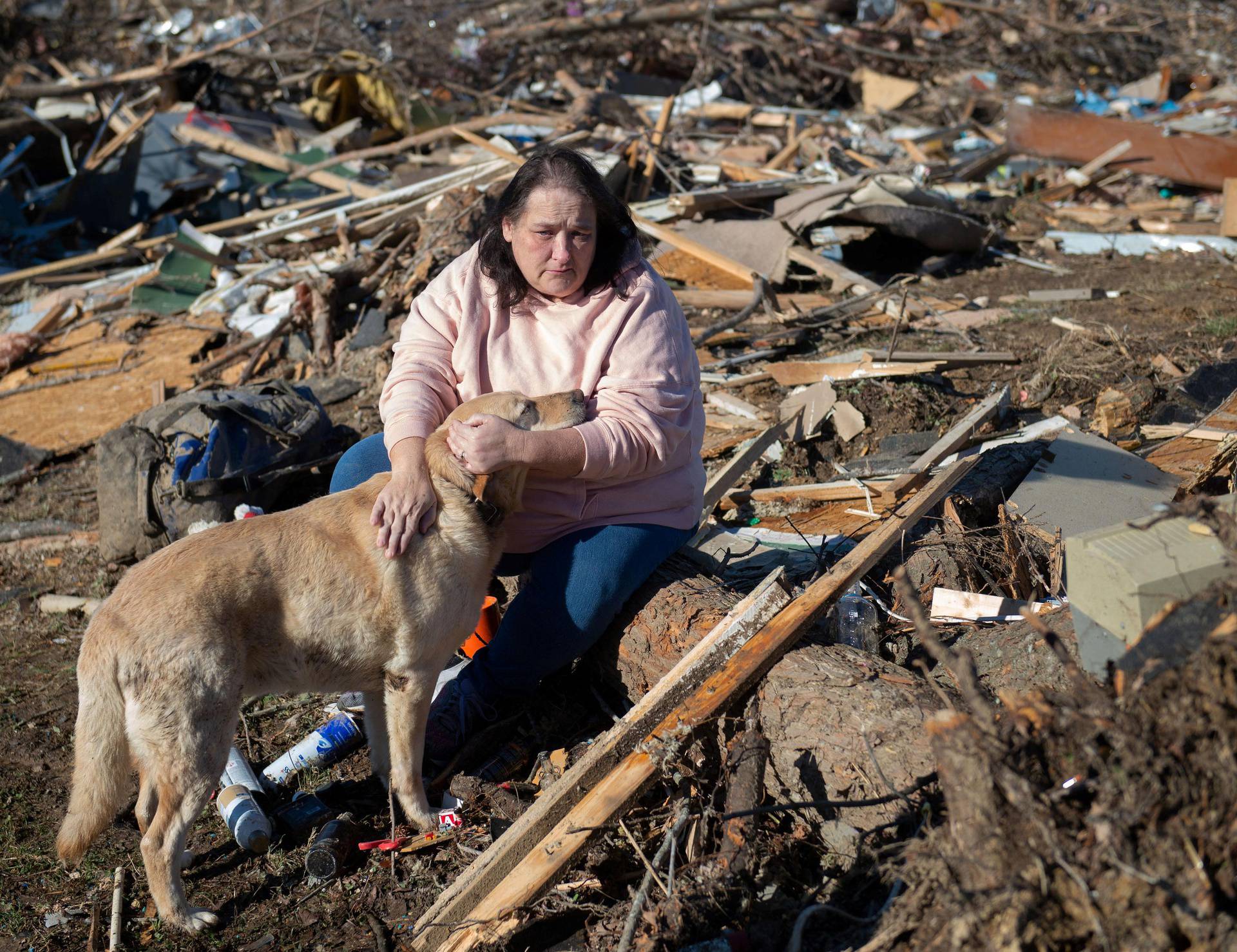 Woman and dog search the debris that once was her sister-in-law's home after the tornado in Bremen
