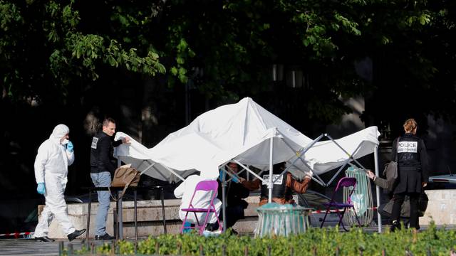 Members of the scientific police stand at the scene of a shooting incident near the Notre Dame Cathedral in Paris