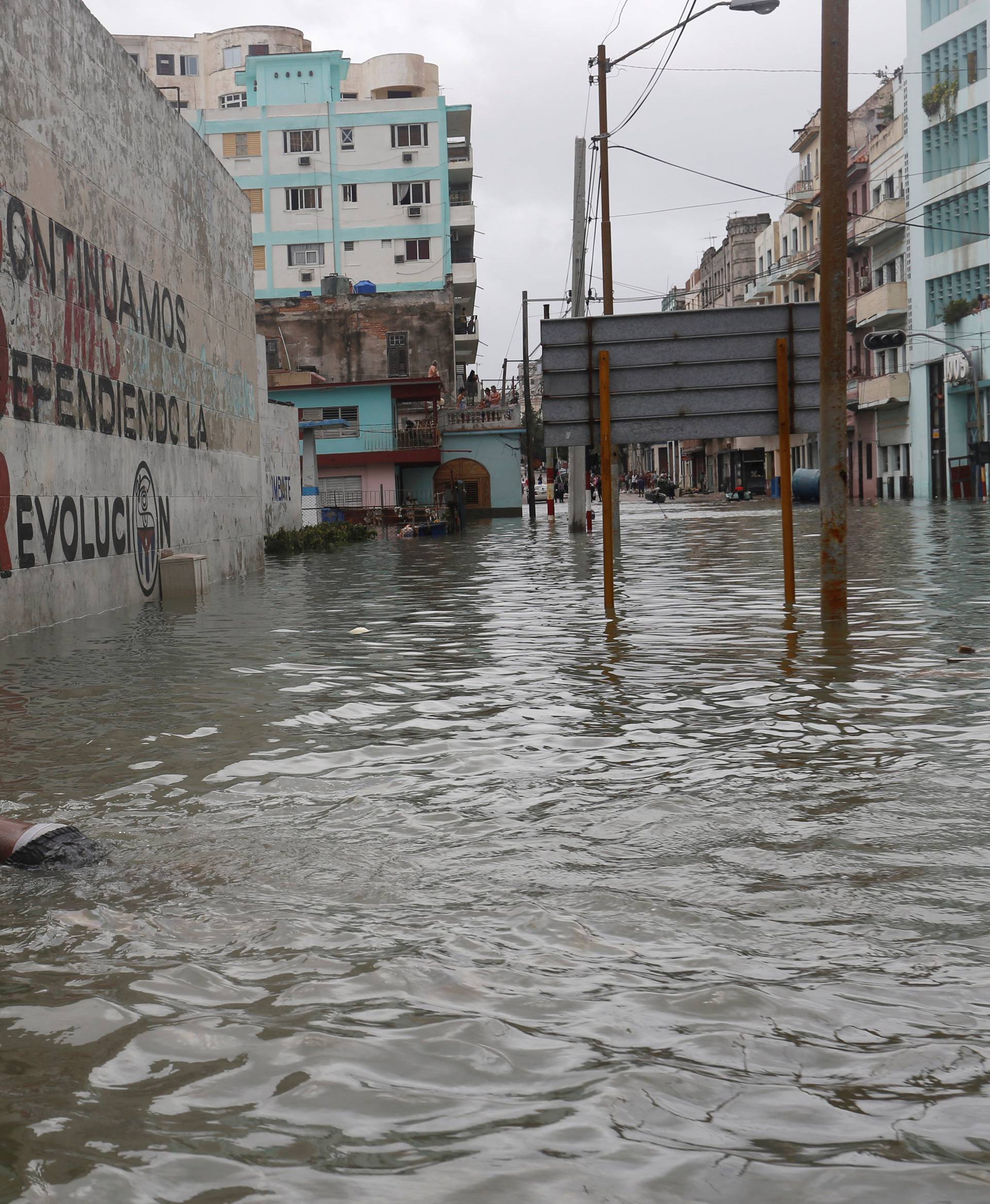 A boy floats with a foam board in a flooded street, after the passing of Hurricane Irma, in Havana