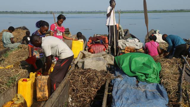 FILE PHOTO: Traders offload beans and jerrycans from their boats on the Congo River during the vaccination campaign against Ebola in the port city of Mbandaka, Democratic Republic of Congo
