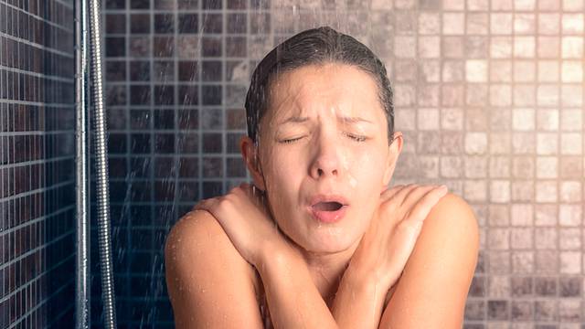Bare Woman Reacting While Taking Cold Shower