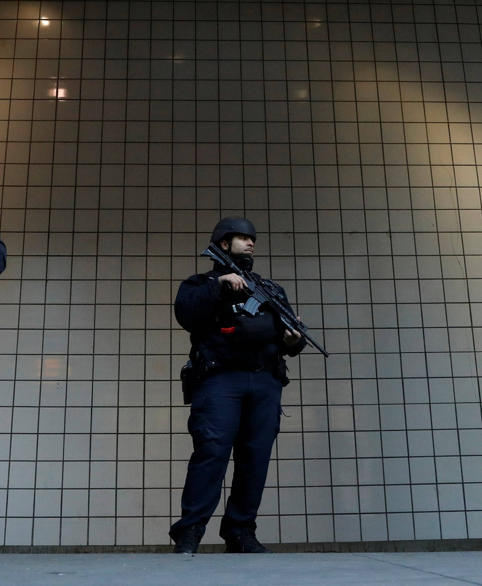 Police officers stand guard outside the closed New York Port Authority Subway entrance following an reported explosion, in New York City