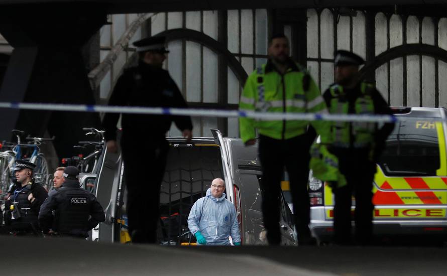 Police officers including one wearing a forensic suit, are seen in a cordoned off area at Waterloo station near to where a suspicious package was found, in London
