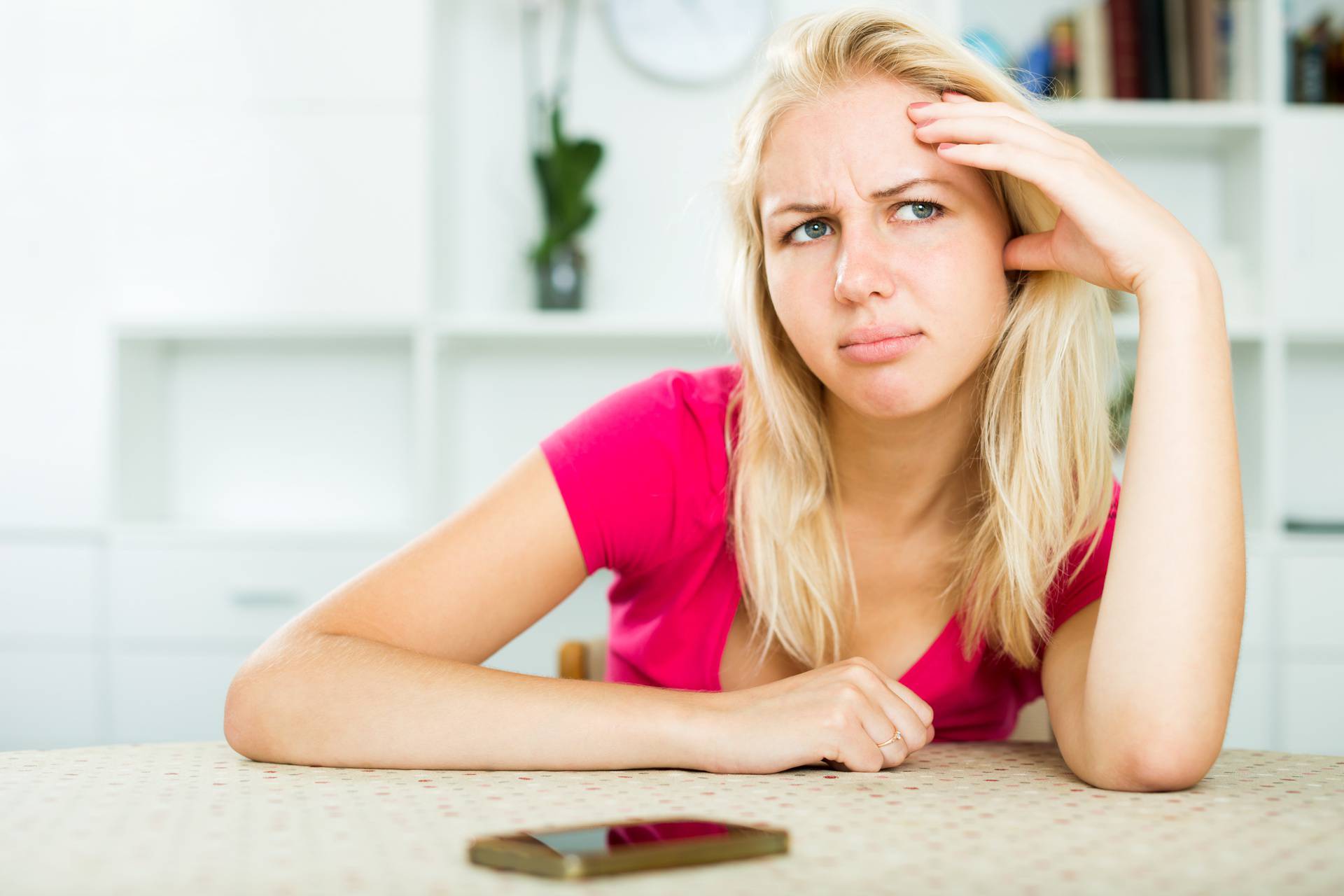 Irritated girl waiting for call sitting indoors 