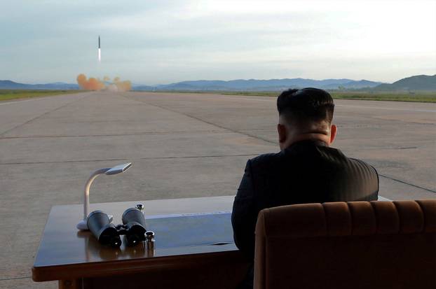 North Korean leader Kim Jong Un watches the launch of a Hwasong-12 missile in this undated photo released by North Korea