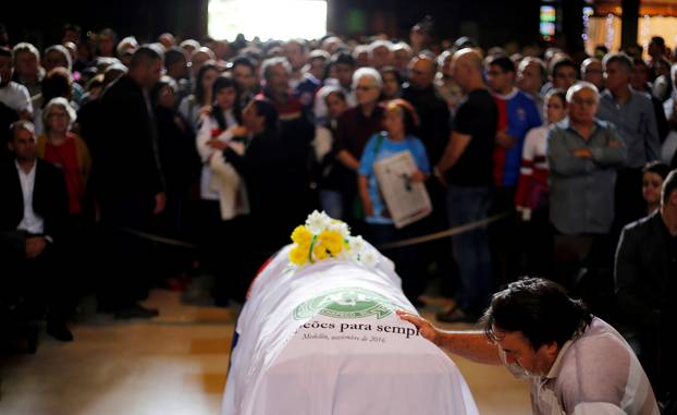 A soccer fan pays tribute next to the coffin of Chapecoense club head coach Caio Junior, who died in the plane crash in Colombia, during a ceremony in Curitiba