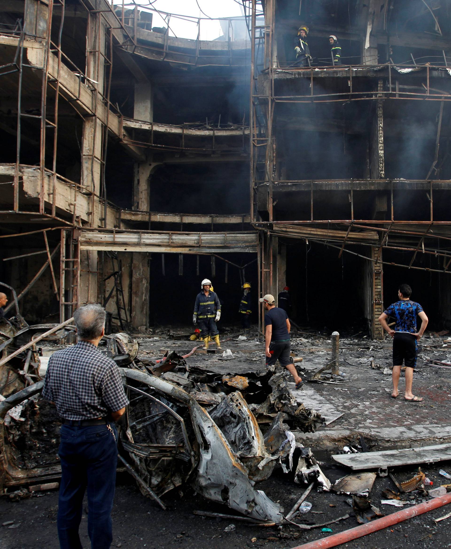 People gather at the site of a suicide car bomb in the Karrada shopping area, in Baghdad, Iraq 