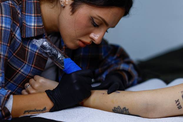 Tattoo artist Valeriia Stashenko makes a tattoo of ears of wheat, which symbolise welfare in Ukrainian tradition, in Kyiv
