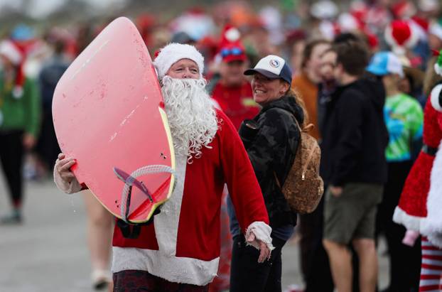 Surfing Santas take to the waves at the annual Christmas Eve event in Cocoa Beach