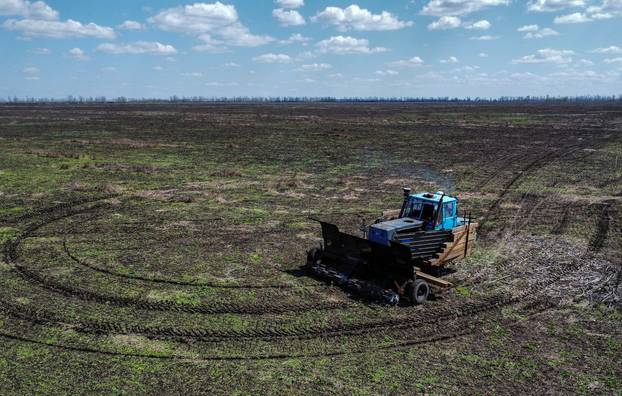 Remote controlled demining machine made of tractor and armoured plates from destroyed Russian military vehicles is seen in a field near the village of Hrakove