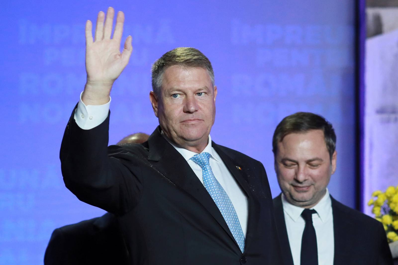 Incumbent candidate Klaus Iohannis waves during a news conference that marked the end of the first round of the presidential election, in Bucharest