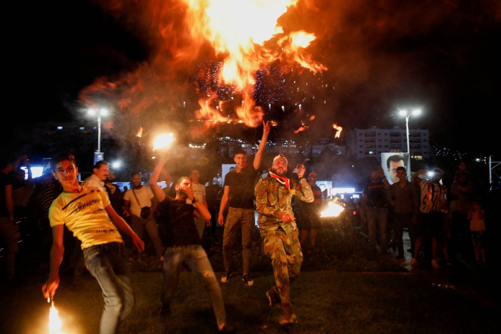 Supporters of Syria's President Bashar al-Assad celebrate after the results of the presidential election announced that he won a fourth term in office, in Damascus