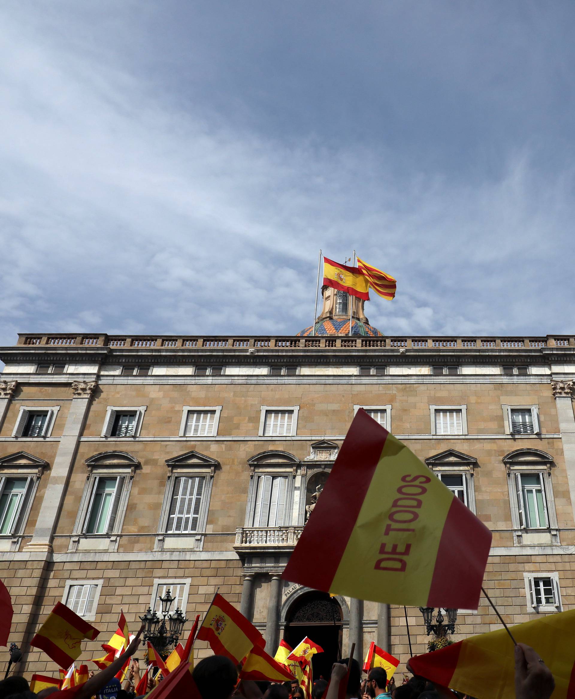 People hold up Spanish flags outside the Palau de la Generalitat, the regional government headquarters, during a demonstration in favor of a unified Spain a day before the banned October 1 independence referendum, in Barcelona