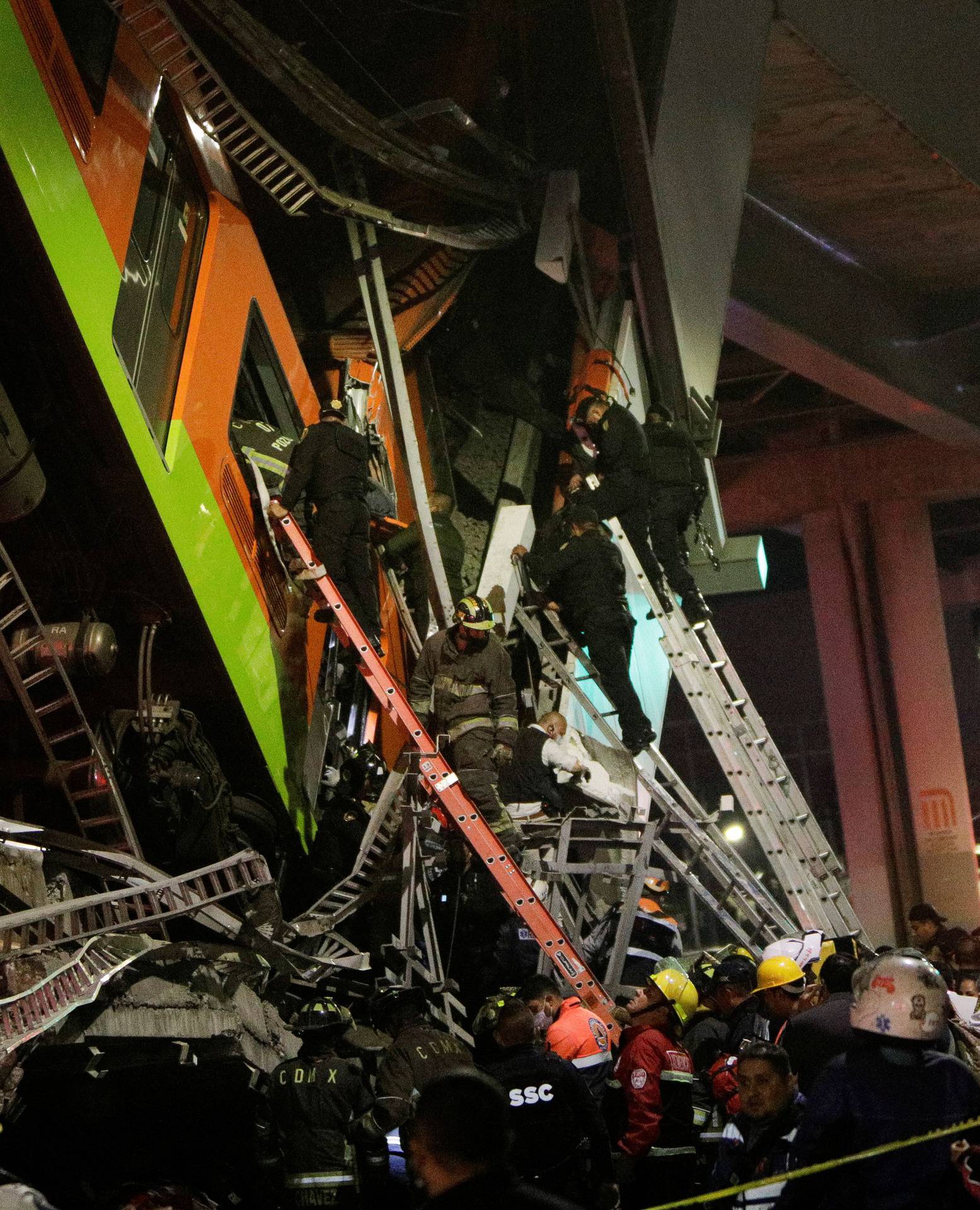 Rescuers work at a site where an overpass for a metro partially collapsed with train cars on it at Olivos station in Mexico City