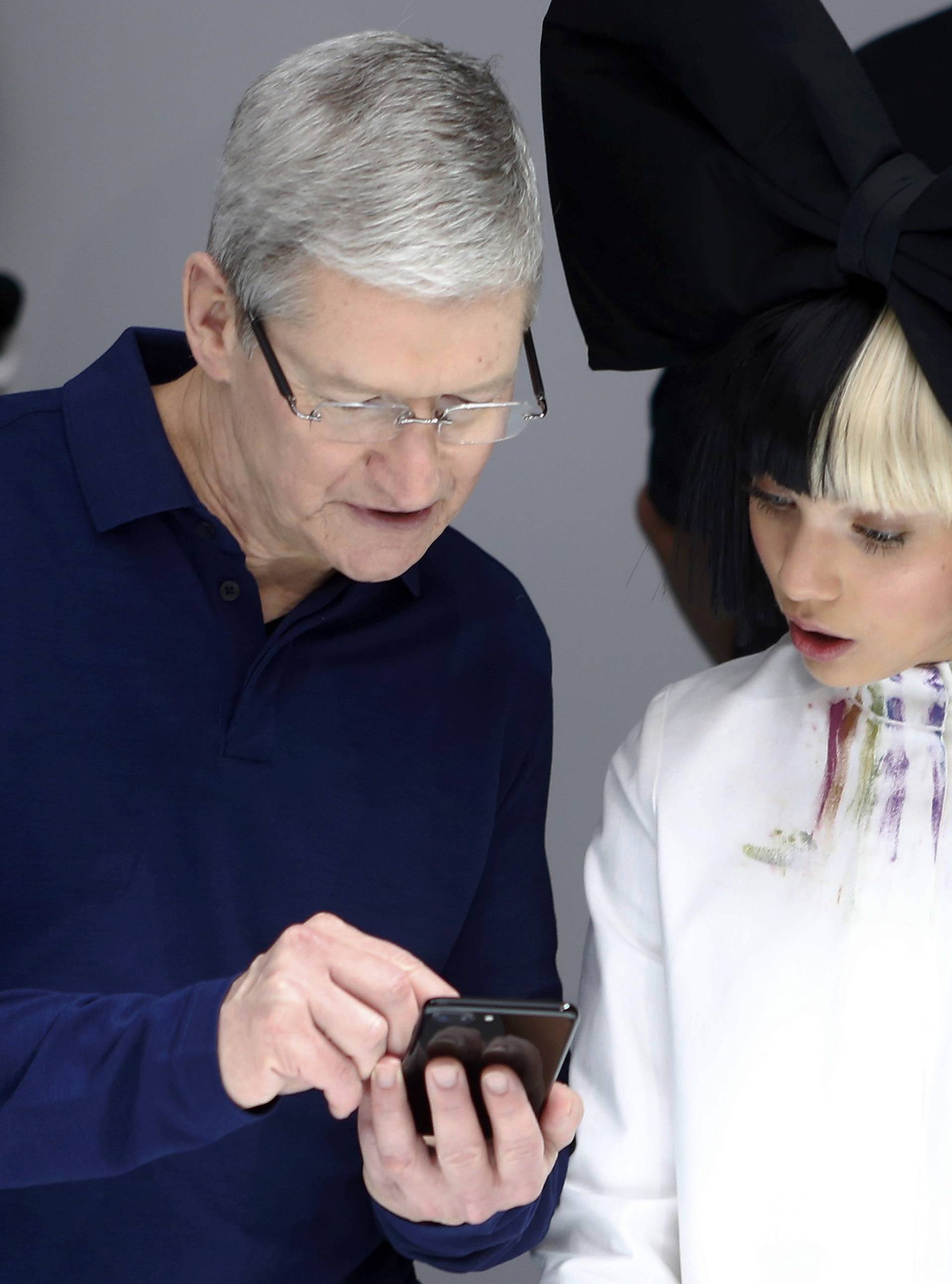 Tim Cook shows Maddie Ziegler an iPhone 7 during an Apple media event in San Francisco