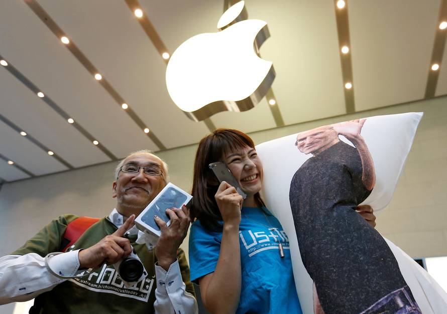 Customers pose with their new Apple's iPhone 7 after purchasing them at the Apple Store at Tokyo's Omotesando shopping district