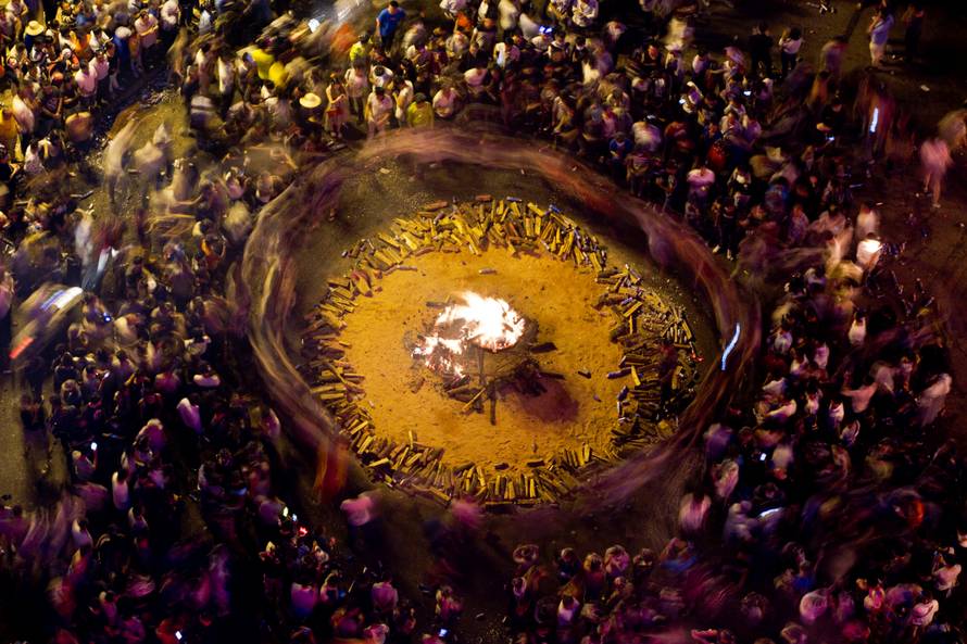 People surround bon fire during a torch festival in Shilin county