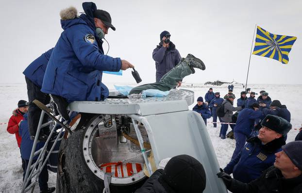 Search and rescue personnel surround the Soyuz MS-09 capsule carrying the International Space Station crew after landing near Zhezkazgan
