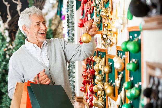 Happy,Senior,Man,Choosing,Christmas,Balls,At,Store