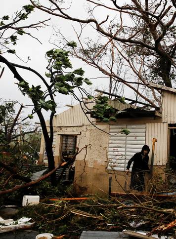 A man looks for valuables in the damaged house of a relative after the area was hit by Hurricane Maria in Guayama