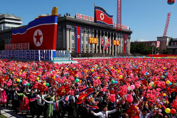 People wave plastic flowers and balloons during a military parade marking the 70th anniversary of North Korea's foundation in Pyongyang