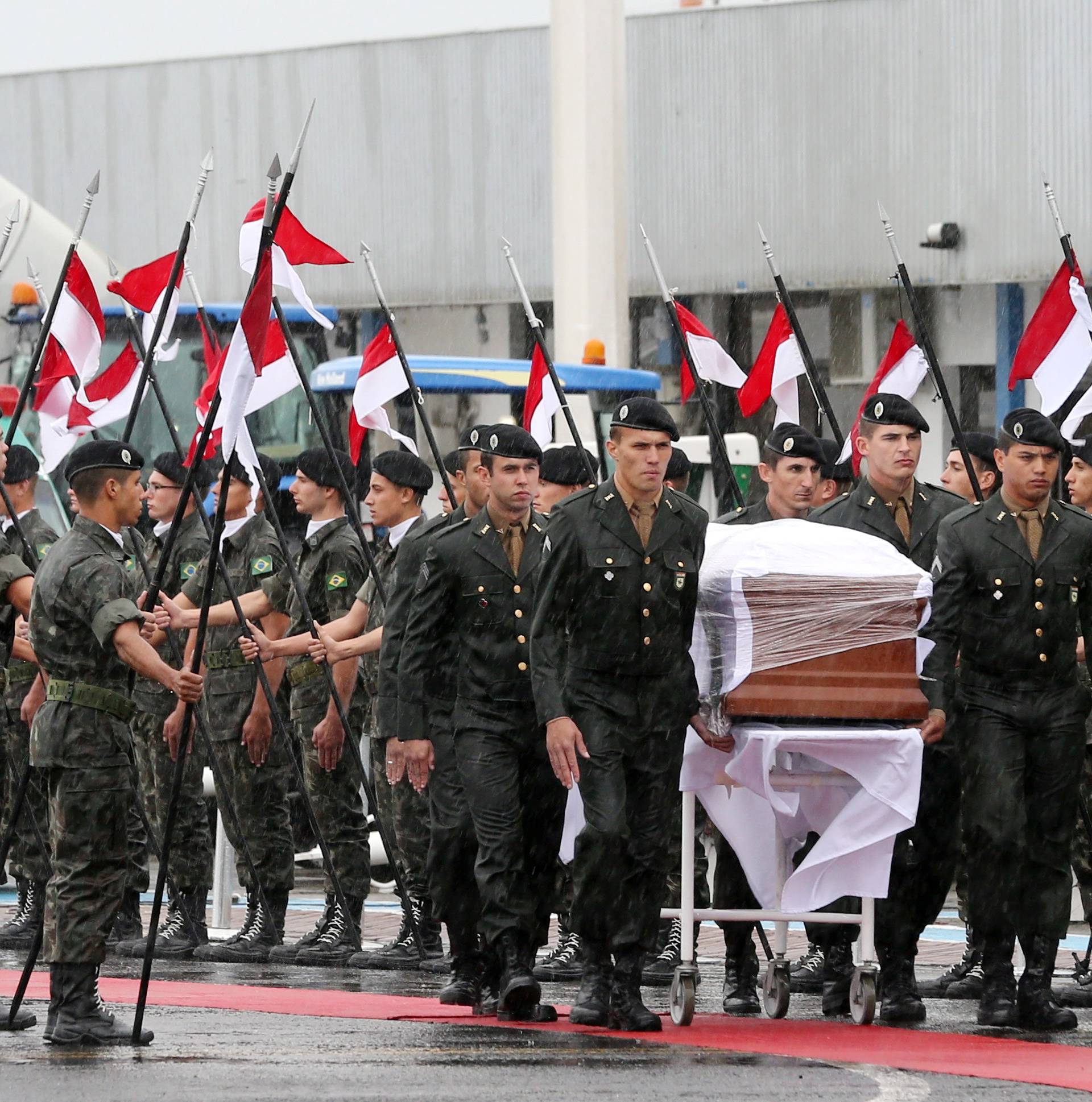 Military personnel carry a coffin containing the mortal remains of a victim of the plane crash in Colombia during arrival in Chapeco