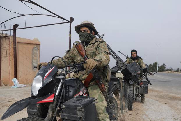 Rebel fighters sit on a motorcycle in Homs countryside